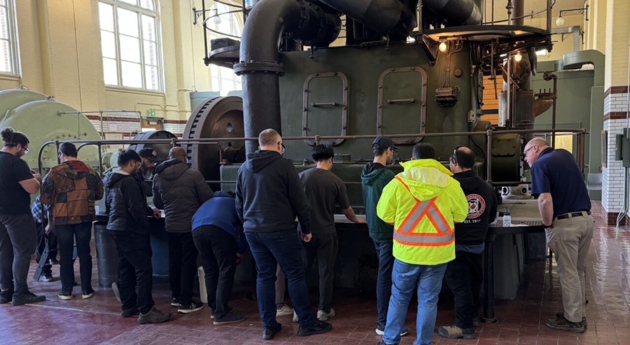 Many operators taking training in front of an equipment