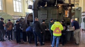 Many operators taking training in front of an equipment