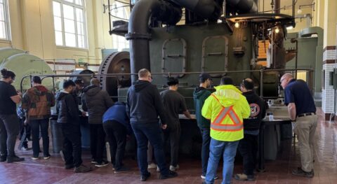 Many operators taking training in front of an equipment