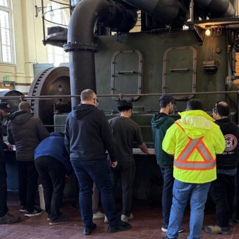 Many operators taking training in front of an equipment