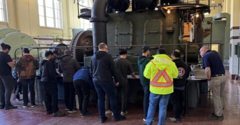 Many operators taking training in front of an equipment