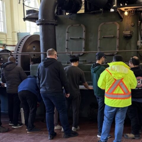 Many operators taking training in front of an equipment